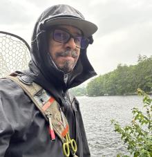 Image of thomas scola, author in fly fish gear on a river
